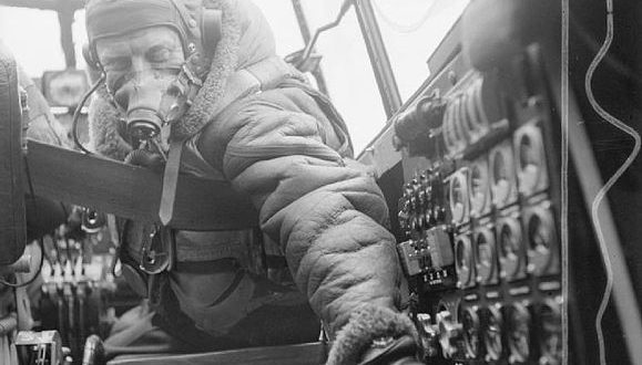 Flying Officer checks settings on control panel on an Avro Lancaster B Mark III